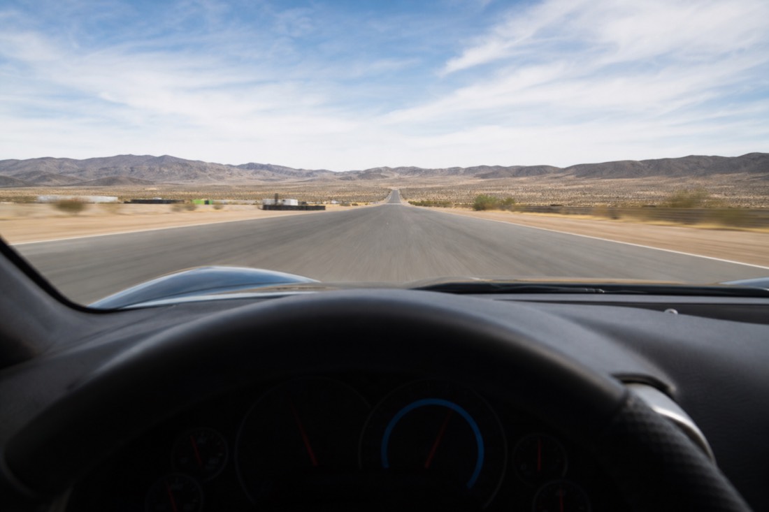 Driver's-eye view down a racetrack straight at speed