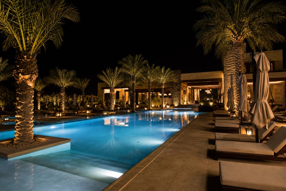 A luxury resort pool deck lit up at night in Las Vegas